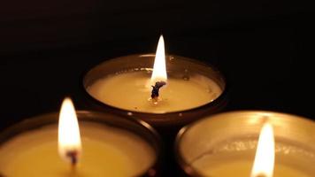 viele klein Kerzen auf ein schwarz Hintergrund. glatt gleiten von Kerzen. Kerzen flackern im das dunkel. schön Aussicht von schimmernd flackern funkeln Beleuchtung. video