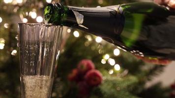 Champagne is gieten in een glas detailopname Aan een Kerstmis achtergrond. video
