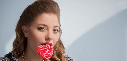 Beautiful girl with a red candy in the form of a heart photo