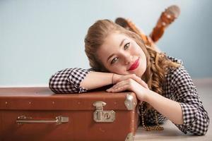 Beautiful pin-up girl. Portrait of a beautiful retro woman. Girl with an old suitcase. photo