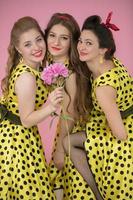 retro chicas. Tres hermosa mujer en amarillo vestidos con polca puntos foto