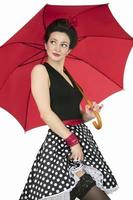 Retro girl with a red umbrella on a white background. Fifties style woman. photo