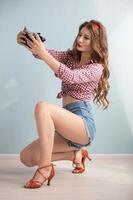 Beautiful retro girl photographer with a vintage photo camera.