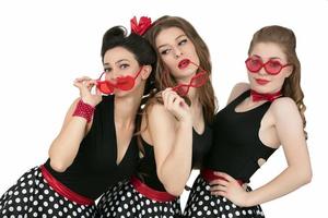 Three beautiful retro girls. A group of women in red glasses. photo