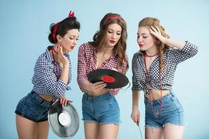 Beautiful girls in the style of the fifties with music records. photo