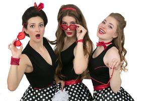 Three beautiful retro girls. A group of women shows emotion of surprise. photo