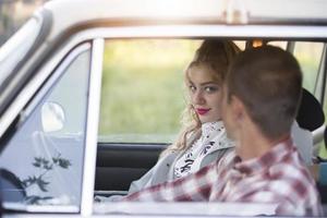 A beautiful girl is sitting with a guy in the car. photo