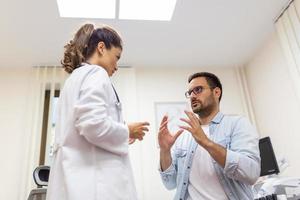 Doctor working in the office and listening to the patient, he is explaining his symptoms, healtcare and assistance concept photo