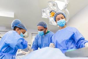 Shot in the Operating Room, Assistant Hands out Instruments to Surgeons During Operation. Surgeons Perform Operation. Professional Medical Doctors Performing Surgery. photo