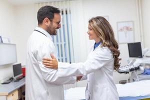 dos profesional confidente médico sacudida manos mientras en pie a el clínica .trabajo en equipo de caucásico médico reunión y saludo por apretón de manos a hospital .médico equipo, salud cuidado concepto. foto