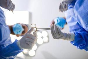 Close-up of gloved hands passing the surgical scissors, operating room, hospital photo
