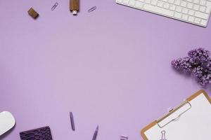 The workspace of a blogger or freelancer Flat lay with a keyboard, notebooks and lilac branches, stationery on a lilac background with a copy space photo