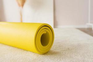 amarillo yoga estera a hogar o en el estudio foto