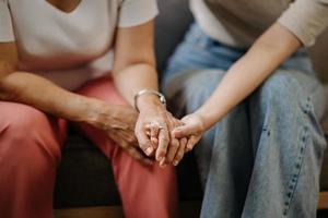 manos de la anciana y una mano de wman en casa foto