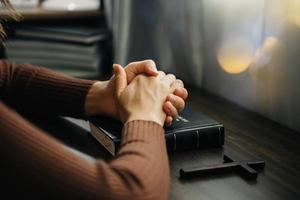 Hands together in prayer to God along with the bible In the Christian concept and religion, woman pray in the Bible photo