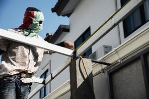 en el sitio construcción trabajador con acero techo estructura instalación, residencial edificio contratista trabajo foto