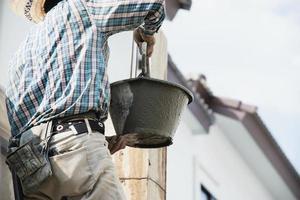 builder contractor man job mix concrete in industry work project, pouring wet liquid material into the column form in construction site as professional employment photo