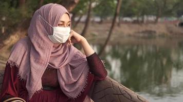 Side view of muslim woman with flu mask at park video