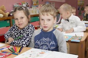 niños sentar a escritorios en el aula. foto