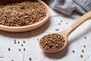 Coriander seed in a spoon on white background photo