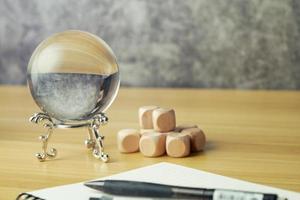 close up fortune-telling or prediction business markets with a crystal ball on desk background and copy space. predict, laptop, probability photo