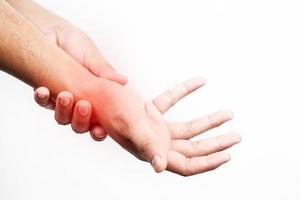 Asian male arms holding his painful wrist caused by exercise. Asian man hand holding his pain wrist isolated on background photo