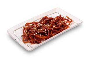 Seasoned dried shredded squid ojingeochae muchim with sesame in dish isolated on white background with clipping path photo