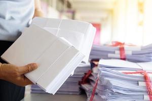 Closeup hands hold stack of used paper to recycle or combine to use next time to print out both sides of paper. Concept, eco friendly activity for environment, reuse paper. photo