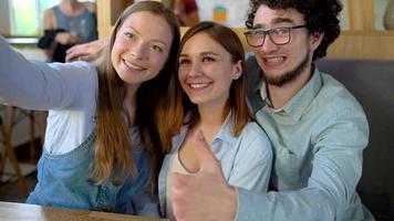 joven amigos sentar en un cafetería, bebida café y tener divertido comunicado. lento movimiento video