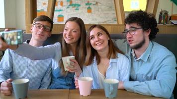 jong vrienden zitten in een cafe, drinken koffie en hebben pret communiceren. langzaam beweging video