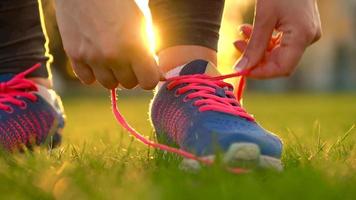 Running shoes - woman tying shoe laces. Slow motion video