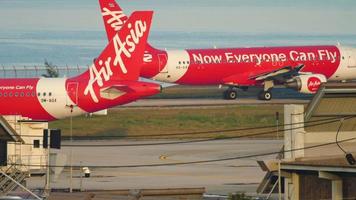 PHUKET, THAILAND NOVEMBER 26, 2019 - Two low cost passenger planes fly in different directions on the airfield at Phuket International Airport. AirAsia plane in Thailand video