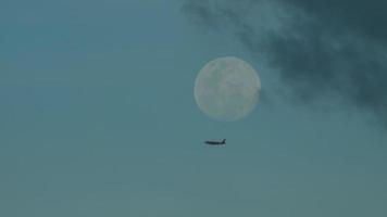 súper lleno Luna terminado Tailandia y silueta de avión. un comercial aeronave volador pasado el Luna video