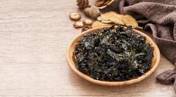 roasted nori seaweed and sesame topping in wood plate on wooden table background. Gim, laver, nori photo