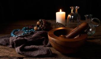 concept of magic potion n a wooden table and white candle with a mortar on dark background. macabre, witchcraft photo