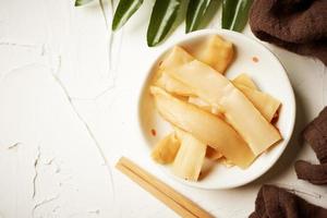 top view Ajitsuke Menma Pickled Bamboo Shoot in a white dish on white table background with copy space photo