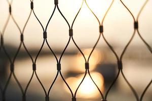 concept of close up the wire fence at sunset blur bokeh background photo