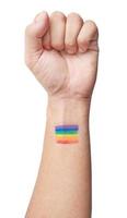 un masculino mano con elevado puño pintado el arco iris bandera o orgullo en aislado blanco antecedentes. lgbt concepto foto