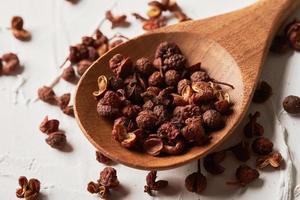 sichuan pepper in spoon on white background photo