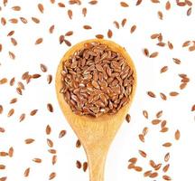 Flax seeds in wooden spoon isolated on white background. photo