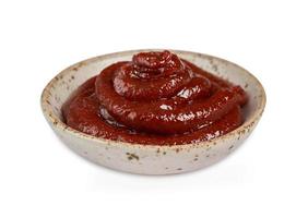 Gochujang or Korean red chili paste in a ceramic bowl isolated on white background with a clipping path. red chili sauce gochujang condiment photo