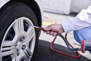 hand and vehicle wheel add air pressure photo