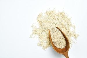 top view white sesame seeds with a wooden scoop on white background with copy space photo