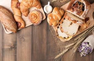 Mix baked bread and wheat on wood table background photo