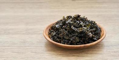 roasted nori seaweed and sesame topping in wood plate on wooden table background. Gim, laver, nori photo