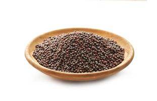 black mustard seed in wood plate isolated on background. a pile of black mustard seed in wood plate isolated on background. heap of black mustard seed in wood plate isolated on background. photo