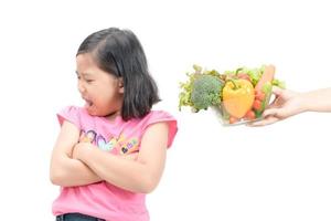 girl with expression of disgust against vegetables photo