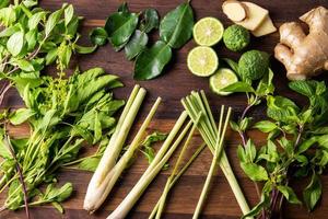 Various fresh asian herbs ingredients food on wooden table photo