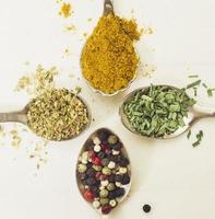 Different spices on spoons photo