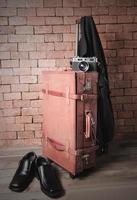 prepare accessories and travel items on brown wooden board and brick background photo